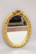 A LOUIS XVI STYLE GILTWOOD OVAL MIRROR.