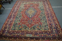 A LARGE PERSIAN CARPET with birds and scrolling branches, within a six row border. Signed. 9ft