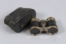 A PAIR OF LEATHER AND METAL OPERA GLASSES in a leather case.
