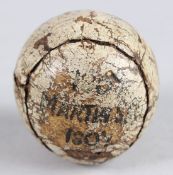 AN EARLY LEATHERBOUND FEATHERIE GOLF BALL stamped King James VI Club, Perth to the front and 1807