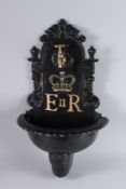 A BLACK PAINTED E.R. CAST IRON WALL FOUNTAIN. 28ins high.