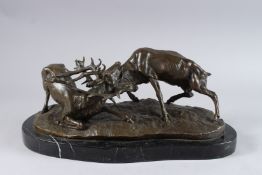 AFTER P. J. MENE. A BRONZE OF FIGHTING STAGS. Signed. 15ins long, on a marble base.