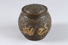 A CHINESE BRONZE GILDED CIRCULAR BOWL AND COVER. 3ins diameter.