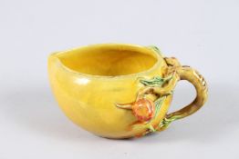 A CHINESE YELLOW PORCELAIN BRUSH WASHER with scrolling handles and two peaches. 4.5ins high.