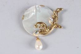 A LARGE MOTHER-OF-PEARL AND GILT BROOCH.