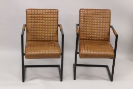 A PAIR OF TAN LEATHER ARMCHAIRS.
