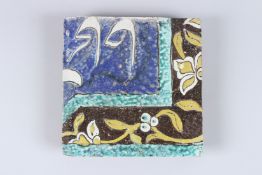 AN ISLAMIC TILE with calligraphy. 8ins x 7.5ins.