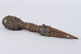 A FINE TIBETAN BRONZE PHURBA DAGGER, the handle as four faces, motifs and calligraphy. 12ins long.