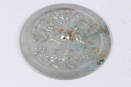 A CHINESE SILVERED BRONZE CIRCULAR HAND MIRROR, cast with various mythological creatures. 20cms