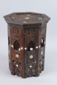 AN ISLAMIC OCTAGONAL TABLE inlaid with mother-of-pearl and bone. 1ft 5ins high x 1ft wide.