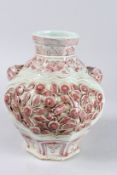 AN OCTAGONAL CHINESE VASE with panels of flowers in relief. 12ins high.