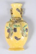 A LATE QING DYNASTY OR EARLY 20TH CENTURY YELLOW GLAZED VASE with raised fruit decoration, 8.5ins