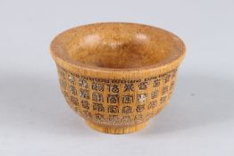 A CHINESE CARVED HORN BOWL with calligraphy. 3.5ins diameter.