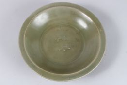 A CHINESE GREEN CELADON CIRCULAR BOWL. 10ins diameter.
