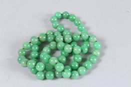 A LONG STRING OF JADE BEADS. 32ins long.