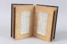 A CHINESE BOOK with jade panels with calligraphy.