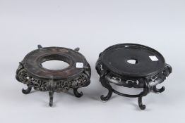 TWO CHINESE CARVED WOOD VASE STANDS. 8ins diameter.