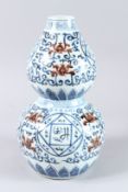 A CHINESE UNDERGROUND RED, BLUE AND WHITE DOUBLE-GOURD VASE. 12ins high.