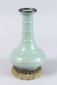 A CHINESE CELADON VASE with stand. Character mark to the base. 9ins high