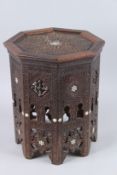 AN ISLAMIC OCTAGONAL TABLE inlaid with mother-of-pearl and bone. 1ft 4ins high x 1ft 1ins wide.