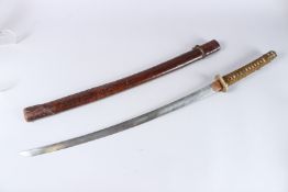 A KATANA with Tsuba and signed blade, the handle with rope work and shagreen. Contained in a leather