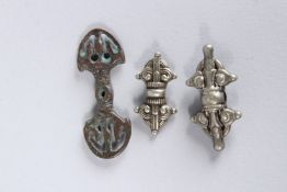 A SMALL COLLECTION OF TIBETAN METAL PENDANTS.