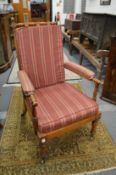 A 19th century mahogany framed open armchair with loose cushions on turned supports with brass
