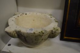 A large weathered marble mortar.