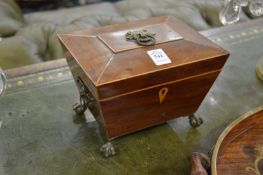 A mahogany casket with claw and ball feet.