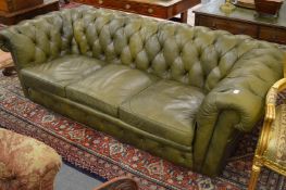 A green leather upholstered Chesterfield three seater settee.