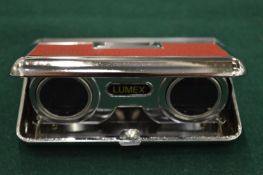 Folding opera glasses or miniature binoculars.