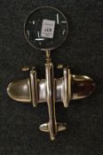 A magnifying glass the handle modelled as an aeroplane.