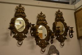 A set of three ornate cast brass twin branch girandoles.