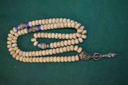 An Eastern bead necklace with silver and enamel decoration.