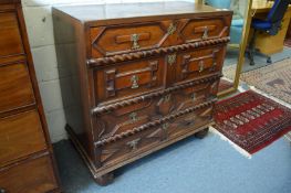An 18th century oak chest of four long geometrically decorated drawers on turned feet.