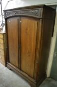 An Art Nouveau oak two door wardrobe (later door panels).