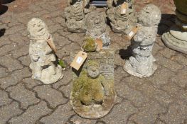 A group of four reconstituted stone garden ornaments modelled as jovial men.