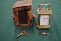 A miniature brass carriage clock with leather travelling case.