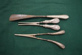 Two pairs of silver handled glove stretchers and a silver handled shoe horn.
