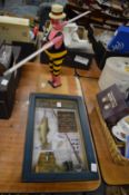 A framed and glazed fishing diorama and a whirligig.