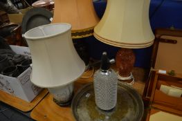 A plated tray, soda syphon and three lamps.