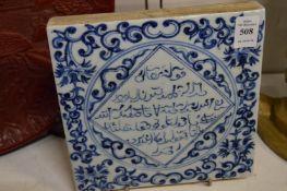 A Chinese blue and white tile with Islamic calligraphy.
