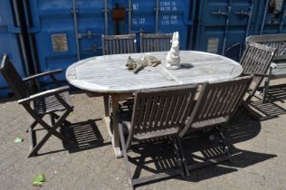 A hardwood garden table and six folding chairs.