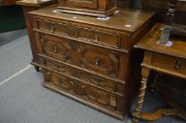 An 18th century oak chest of four long drawers with geometric panelled decoration.