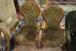 A good pair of Victorian carved walnut framed button upholstered chairs, one with arms.