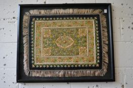 Decorative Eastern gilt metal and gem set embroidered textile or rug, framed and glazed.