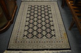 Modern Persian style rug, black ground with stylised decoration, 185cm x 126cm.