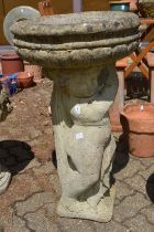 A large reconstituted stone pedestal planter, the base modelled as a cherub.