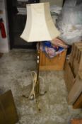 An ornate brass floor standing lamp and a brass spark guard.