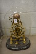 A good brass skeleton clock on a marble base under a glass dome.